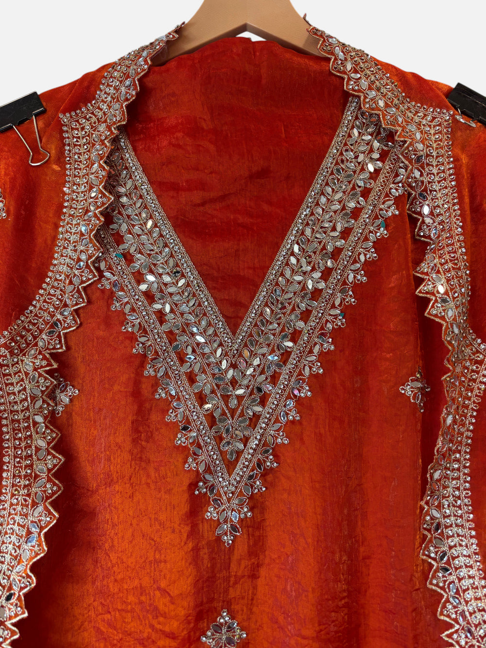 Design by Pakiza orange glass organza shirt featuring a V-neckline with intricate silver mirror and stone embroidery