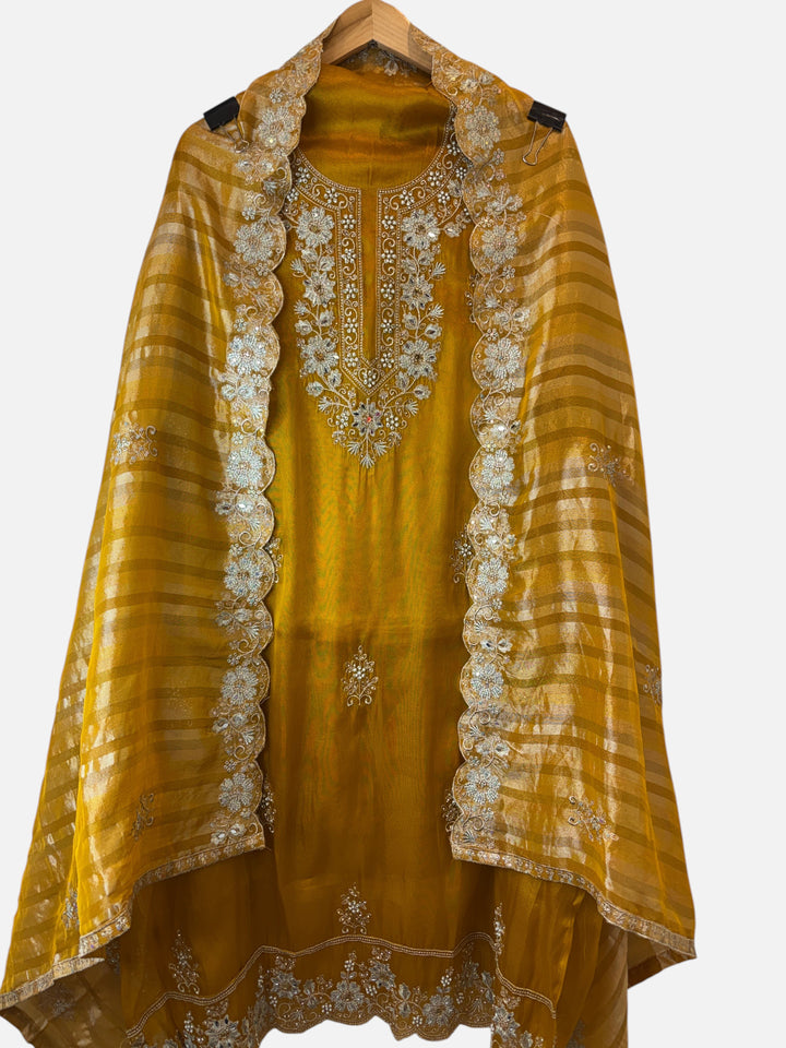 Design by Pakiza mustard glass organza ensemble with intricate zari, pearl, and sequin embroidery and cutwork dupatta.