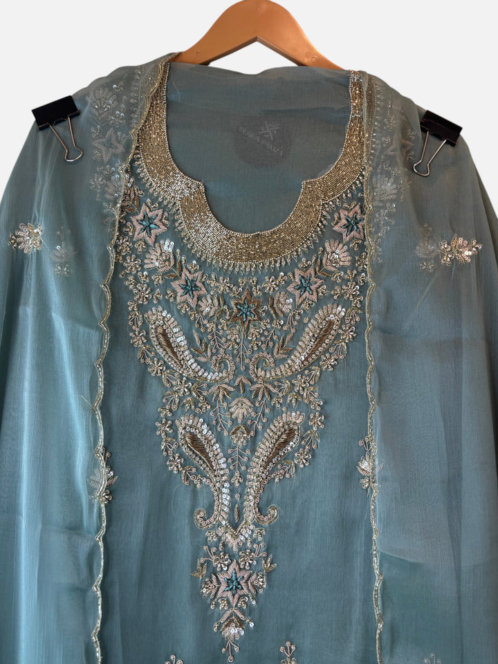 Design by Pakiza Ameera tissue ensemble with intricate zari, pearl, and sequin embroidery on a soft teal fabric.