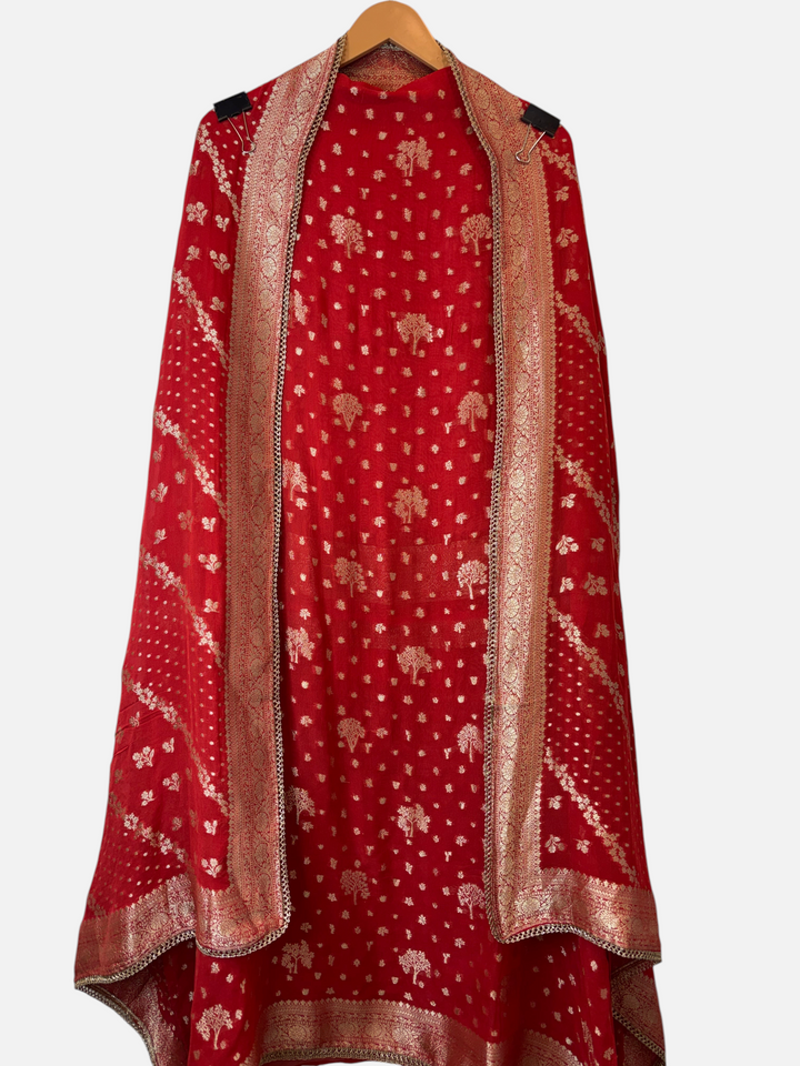 Design by Pakiza orange khadi georgette Banarasi woven dupatta with intricate gold lace detailing on a hanger