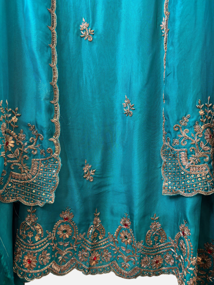 Design by Pakiza teal silk organza ensemble with intricate gold zardozi, dabka, and sequin embroidery details.