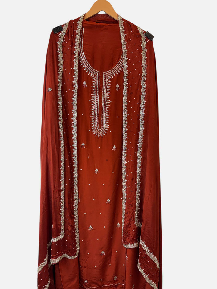 Design by Pakiza rust red crepe 3-piece suit with pearl and cutdana handwork, featuring an embellished chinon dupatta.
