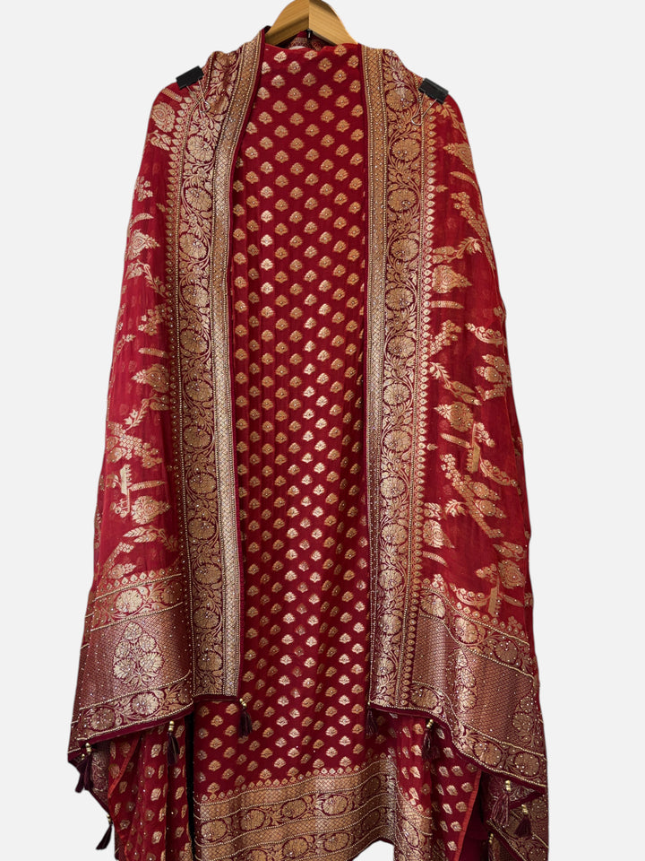 Design by Pakiza red khadi georgette suit with intricate multi-gold jaal patterns and traditional tassel details