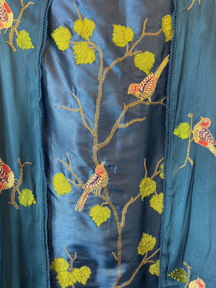 Design by Pakiza teal blue silk fabric with intricate bird appliqué, dabka embroidery, and delicate bead detailing.