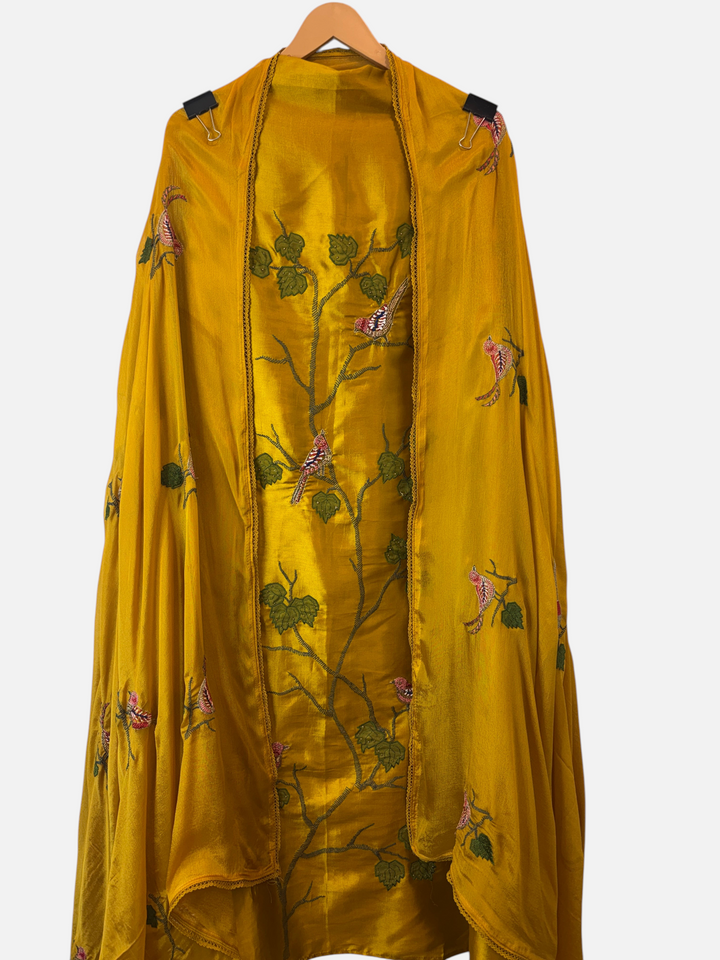 Design by Pakiza mustard yellow silk suit with intricate bird appliqué, dabka embroidery, and matching chinon dupatta.
