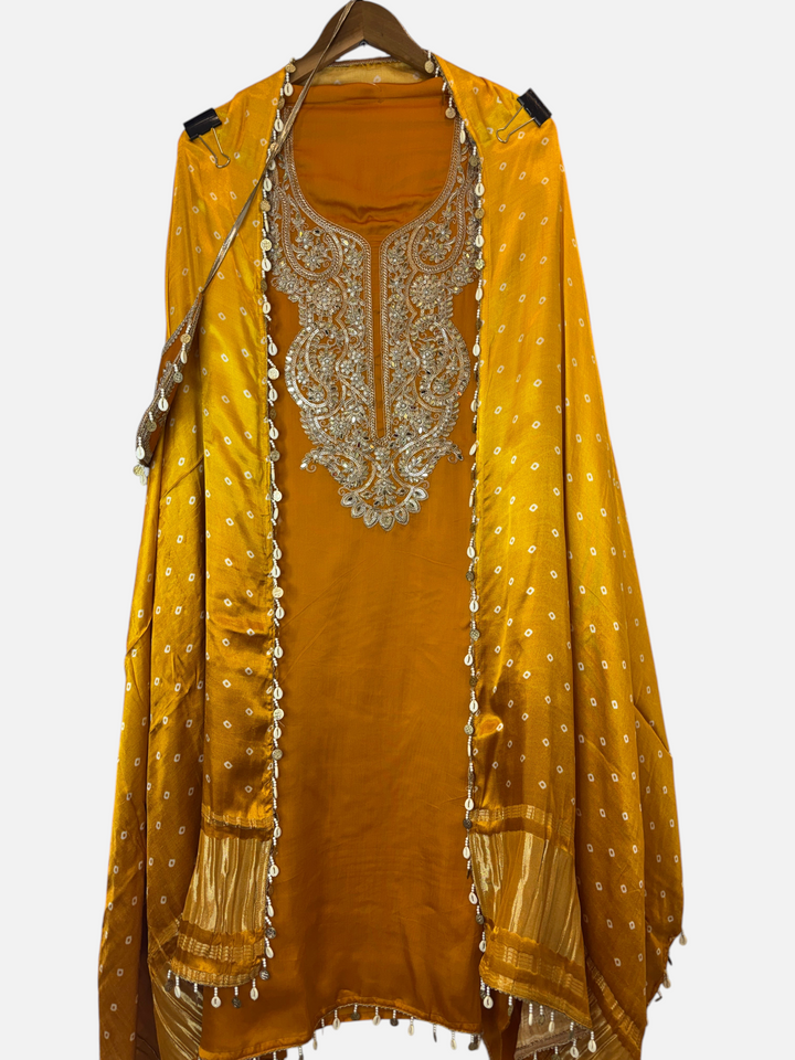 Design by Pakiza mustard yellow satin organza suit with intricate dori, mirror embroidery, and delicate tassel details.