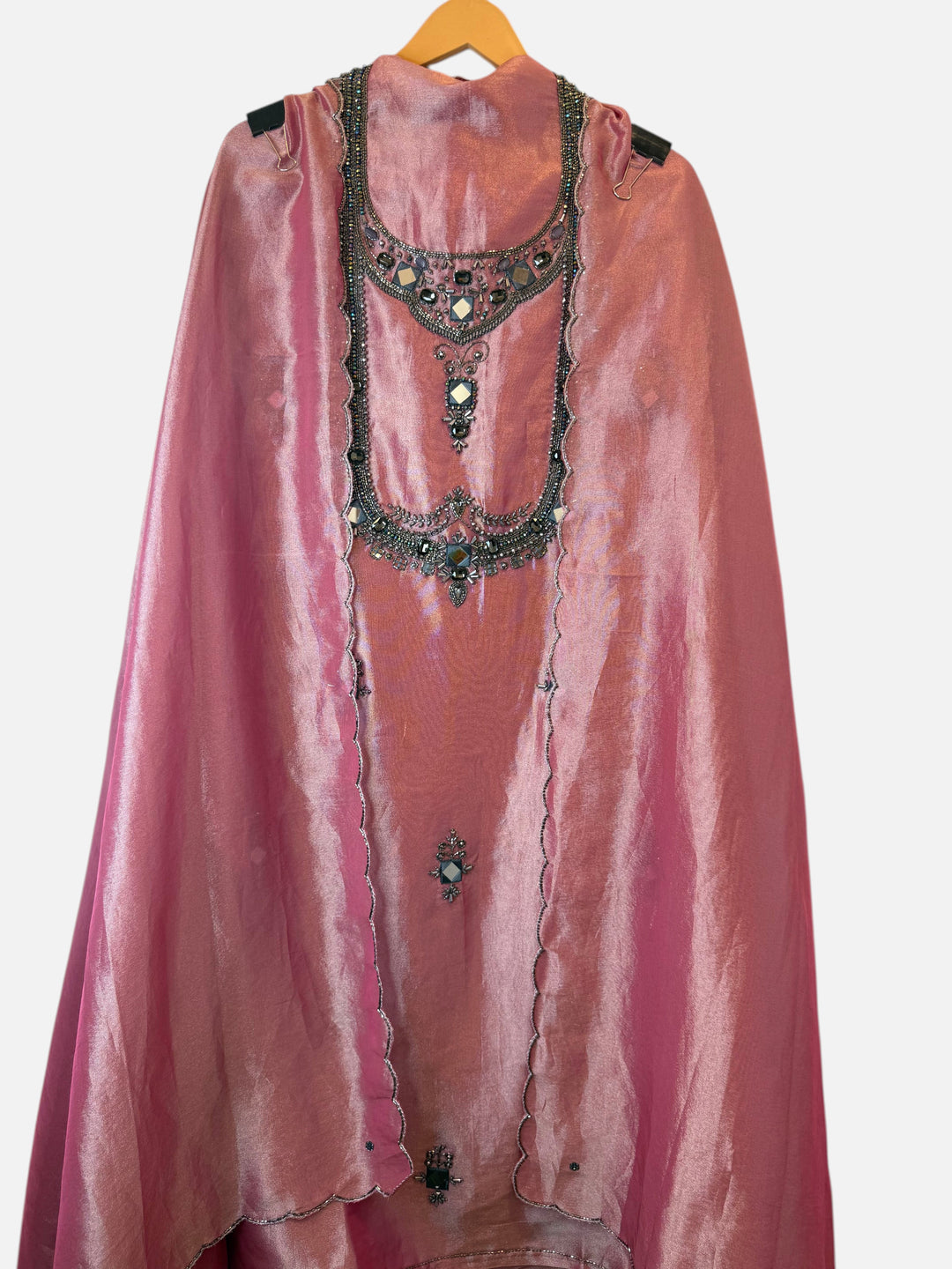 Design by Pakiza pink Kanjivaram unstitched shirt with intricate dori, sequin, and stone embellishments on a hanger.